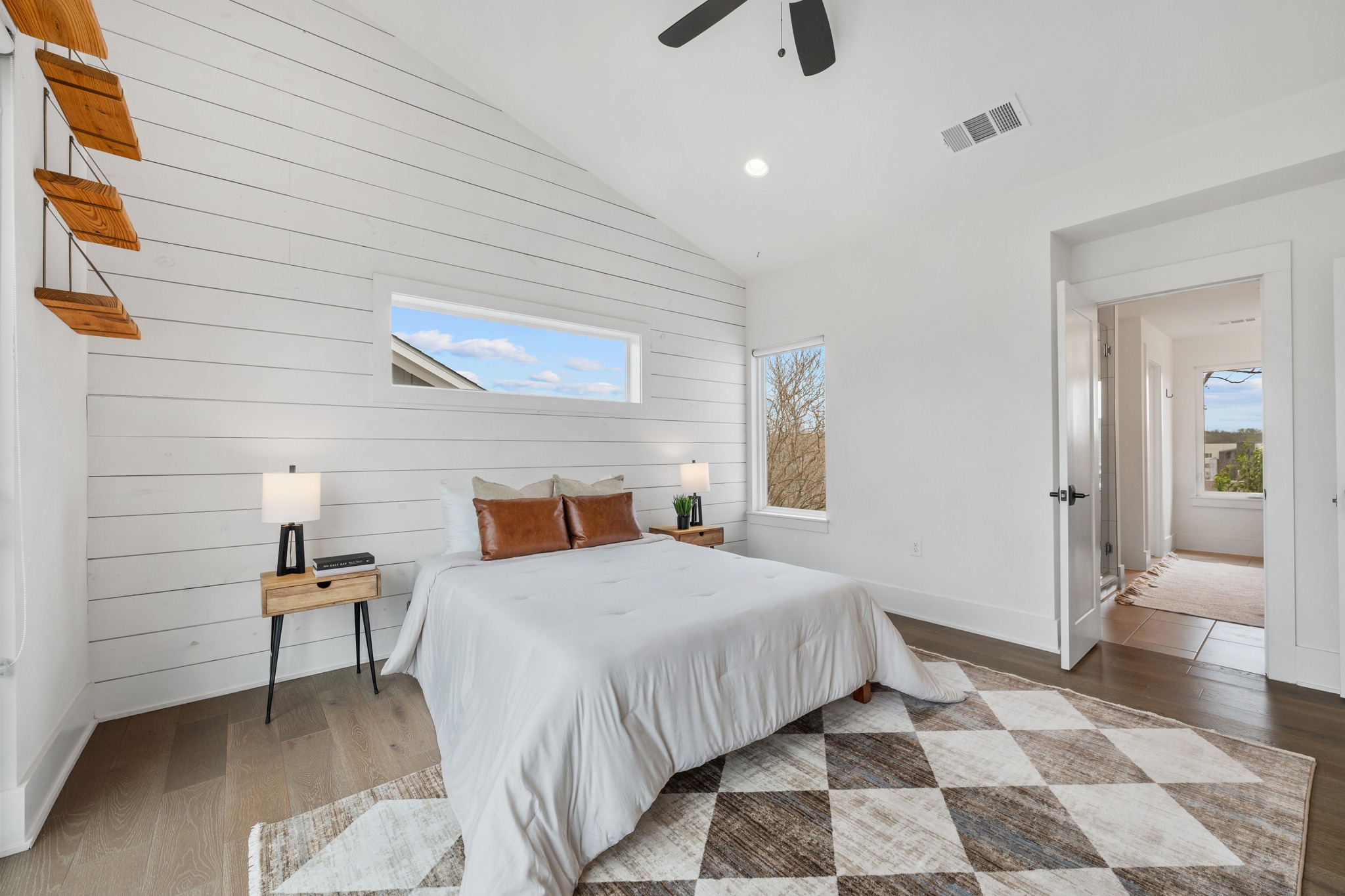 5000 Baker Street Austin, TX 78721 - Photo 28 of 40 A shiplap accent wall adds character to the primary bedroom, creating a focal point behind the bed while still leaving plenty of room for different furniture arrangements