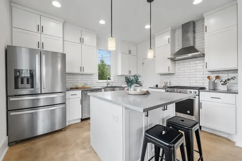 a kitchen with a sink stainless steel appliances and white cabinets