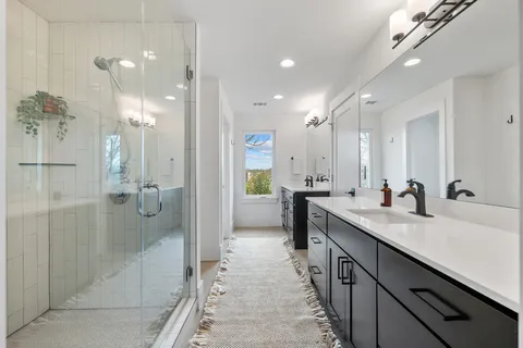 a bathroom with a granite countertop sink mirror and shower