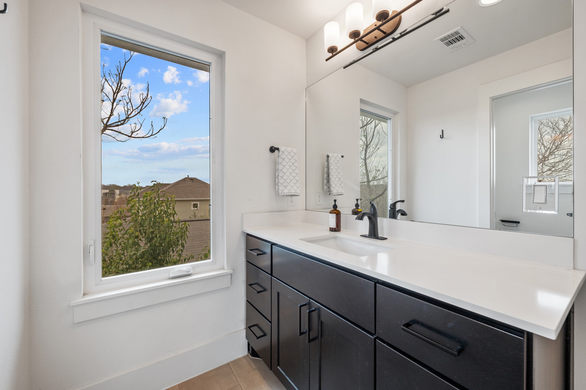 5000 Baker Street Austin, TX 78721 - Photo 32 of 40 The ensuite bathroom features two separate vanities, providing individual space for daily routines and storage