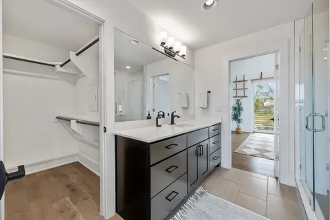 a spacious bathroom with a granite countertop sink a mirror and a shower