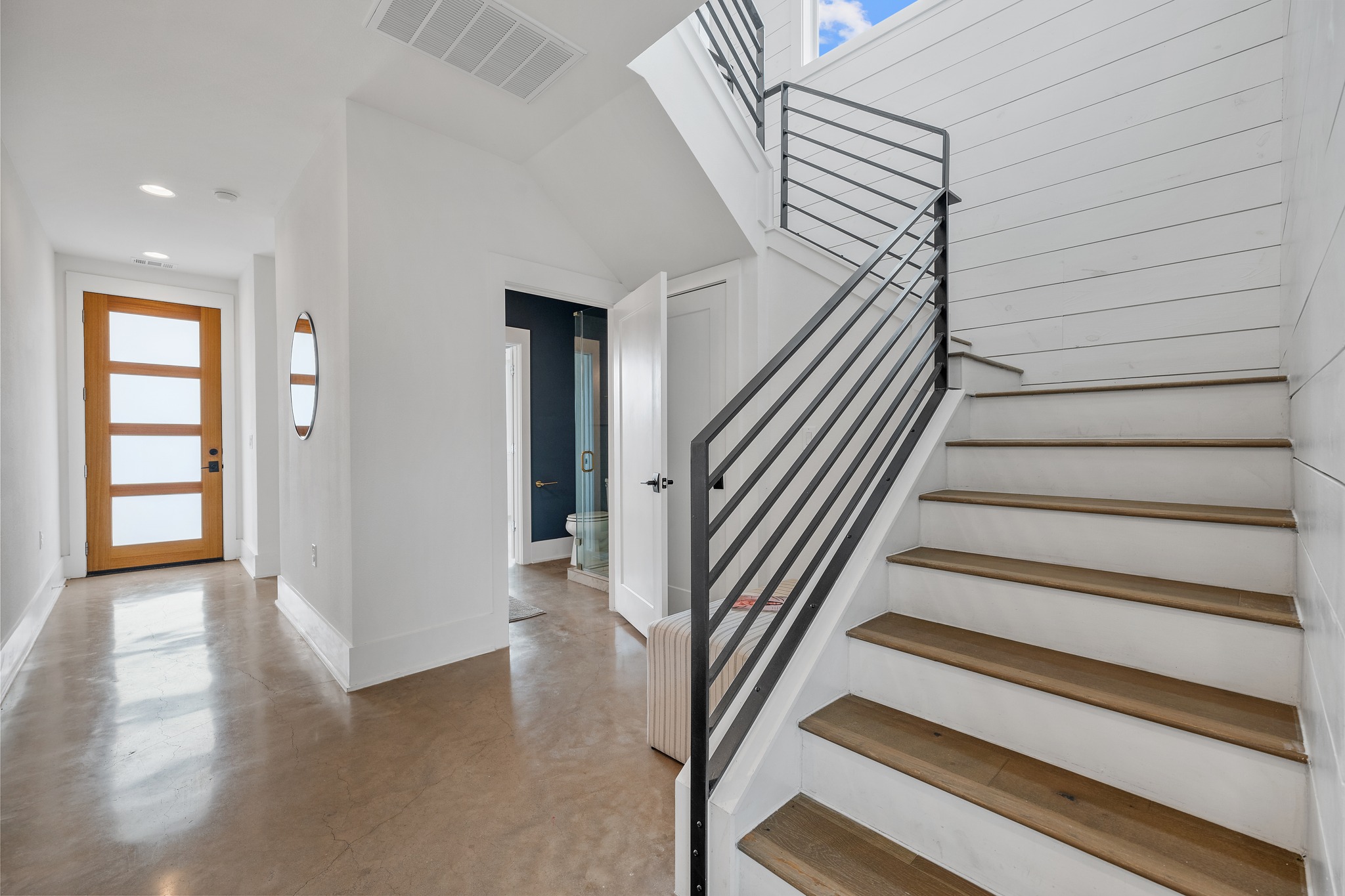 5000 Baker Street Austin, TX 78721 - Photo 10 of 40 The mahogany front door opens to an entry framed by stained concrete floors that continue across the entire main level