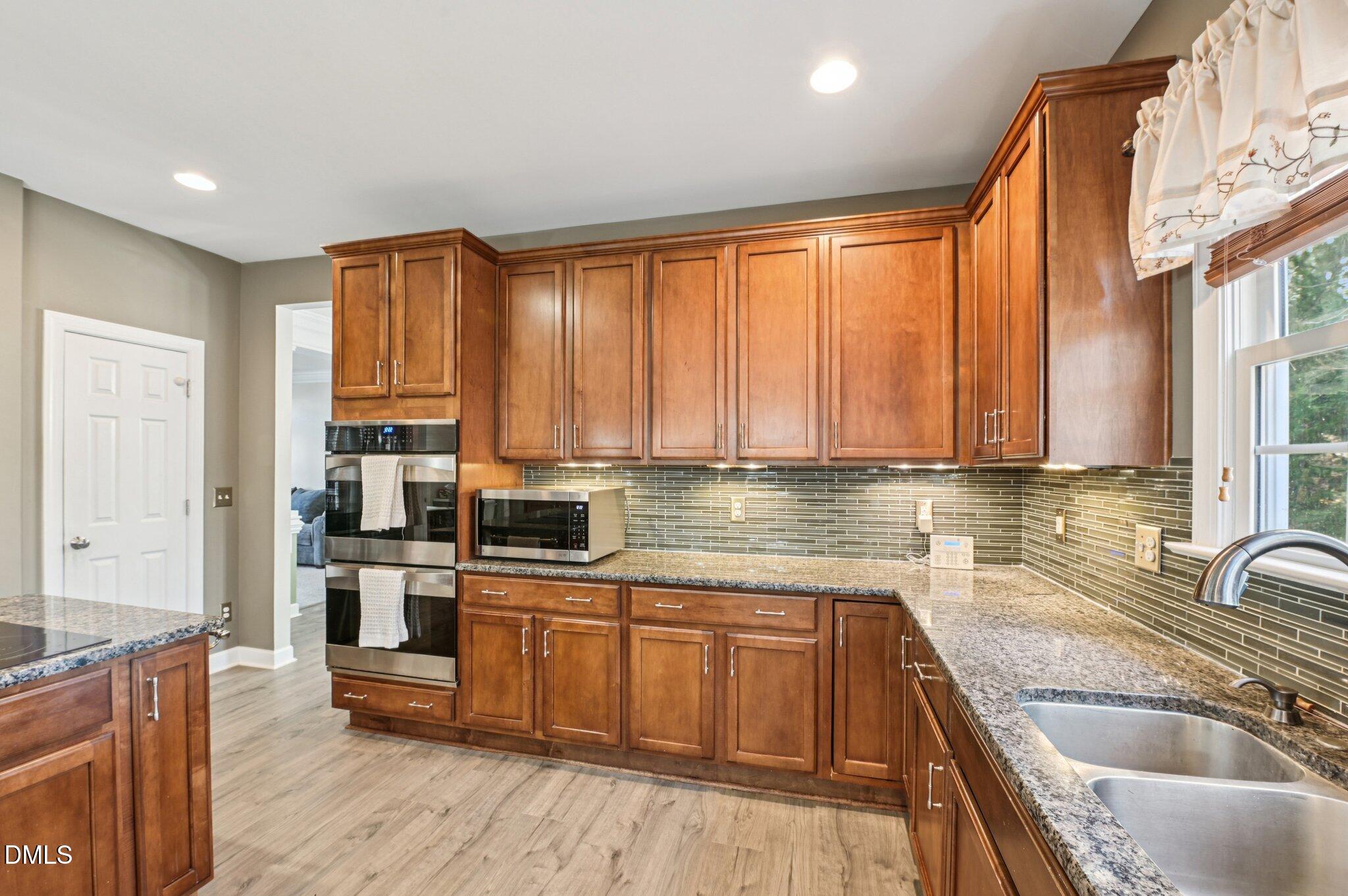 7 Brightfield Lane Durham, NC 27712 - Photo 13 of 41 a kitchen with stainless steel appliances wooden cabinets a sink and a stove