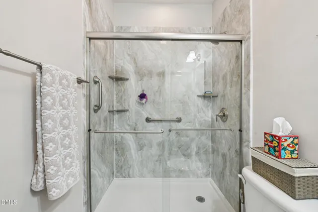 a bathroom with a shower and a sink a mirror