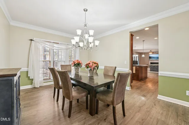 a view of a dining room with furniture a chandelier and wooden floor