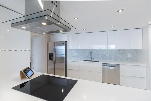 a kitchen with stainless steel appliances granite countertop a sink and a refrigerator