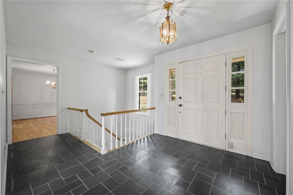 45 Stonedale Road Sewickley, PA 15143 - Photo 18 of 26 The foyer welcomes with a classic charcoal slate tile floor, white paneled front door, and open staircase leading to the lower level.