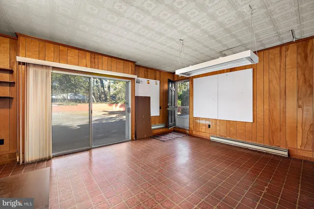 an empty room with a window and a ceiling fan