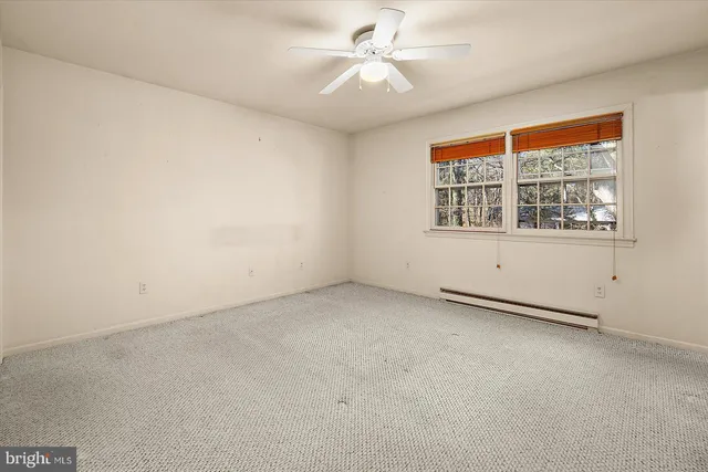 an empty room with a ceiling fan and a window