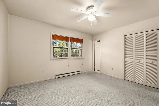 an empty room with a window and a ceiling fan