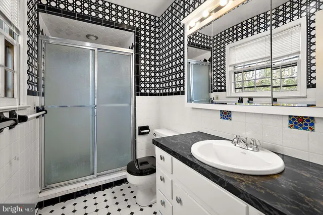 a bathroom with a sink a toilet and mirror