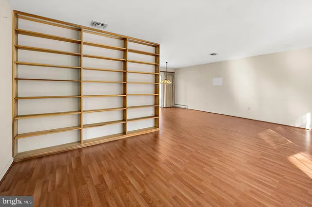 a view of a room with wooden floor and a window