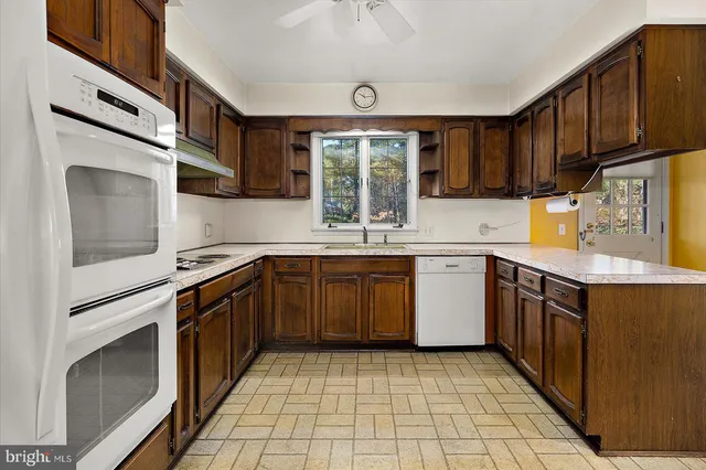 a kitchen with a sink window and cabinets