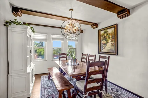 a view of a dining room with furniture a chandelier and wooden floor