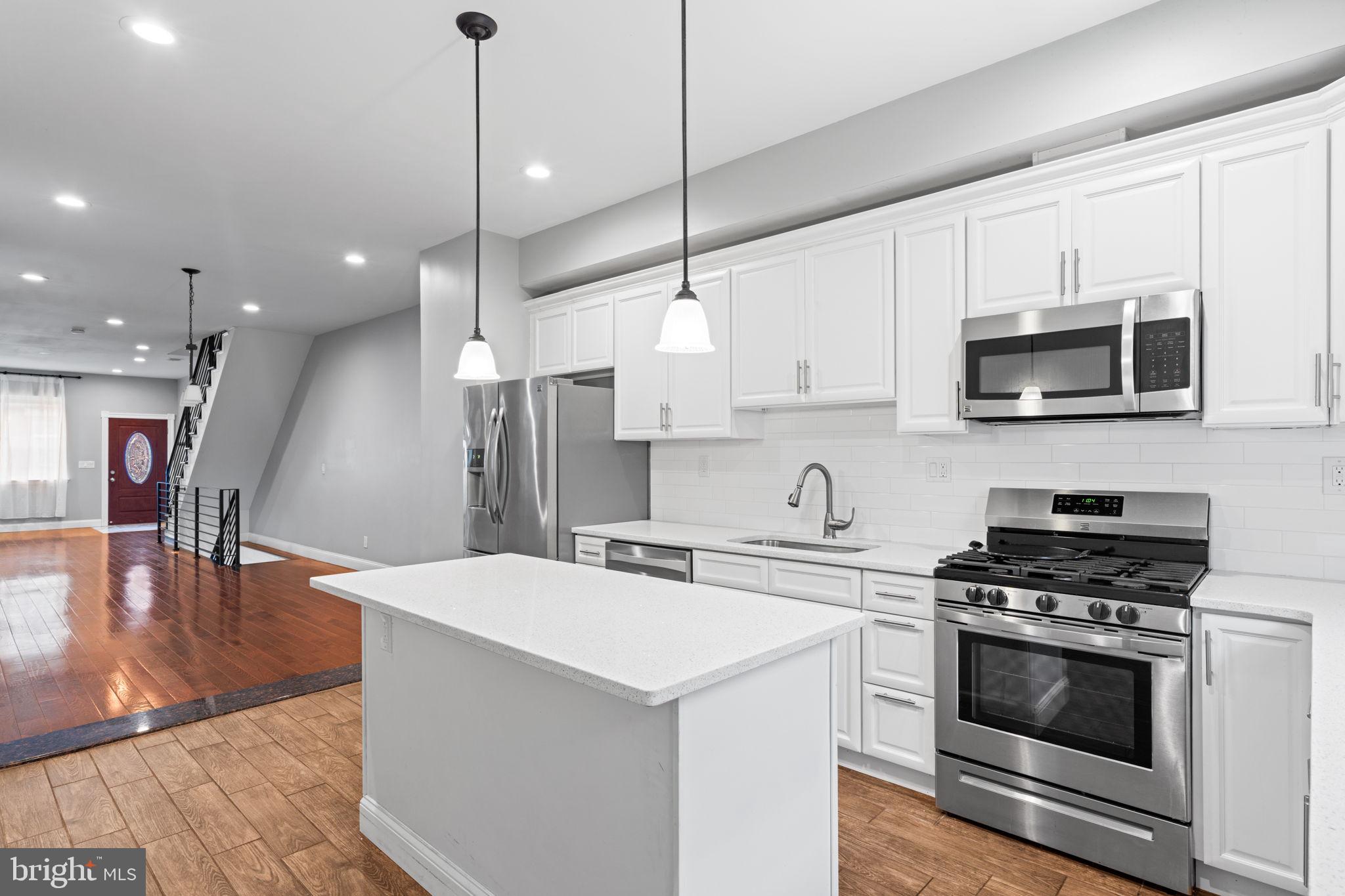1926 Moore Street Philadelphia, PA 19145 - Photo 11 of 31 a kitchen with stainless steel appliances kitchen island a white cabinets and stove top oven