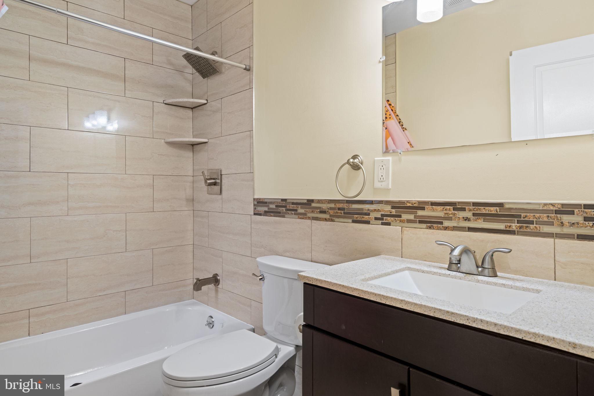 1926 Moore Street Philadelphia, PA 19145 - Photo 22 of 31 a bathroom with a granite countertop sink vanity mirror bathtub shower and toilet