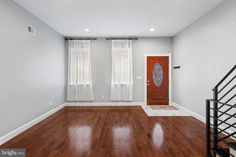 an empty room with wooden floor and a window