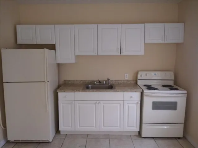 a kitchen with cabinets appliances a sink and a counter space