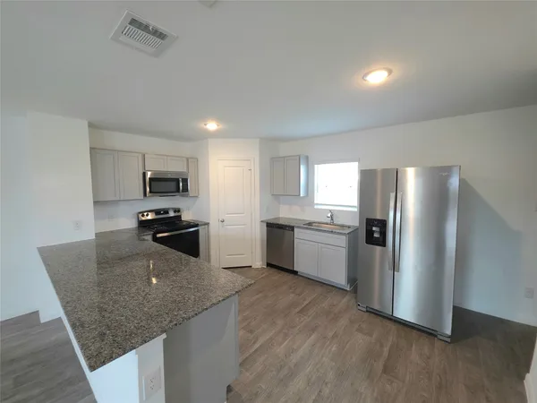 a kitchen with refrigerator and microwave