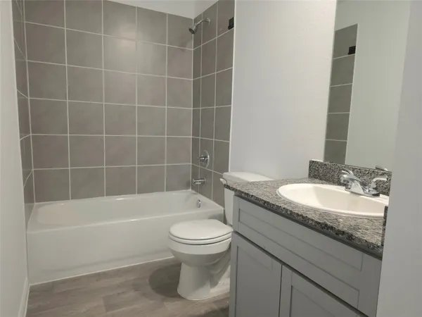 a bathroom with a granite countertop toilet a sink and bathtub