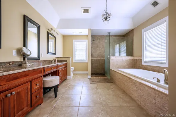 a spacious bathroom with a tub sink and mirror