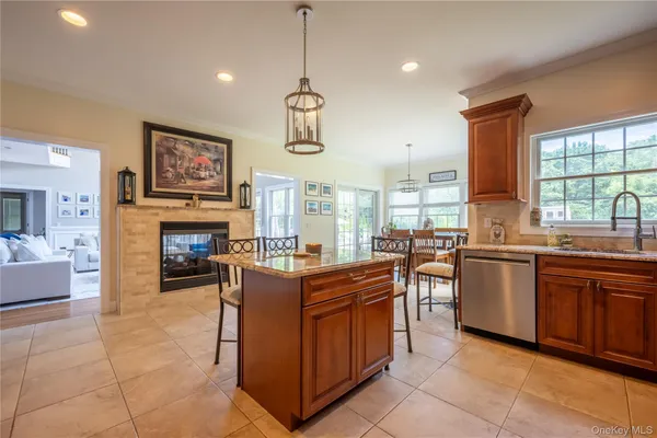 a kitchen with stainless steel appliances granite countertop a stove top oven a sink dishwasher a dining table and chairs with wooden floor