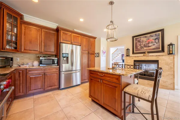 a kitchen with stainless steel appliances granite countertop a stove top oven a refrigerator a sink dishwasher and wooden cabinets