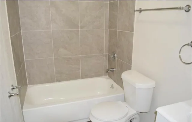 a white toilet and tub sitting next to a bathroom sink