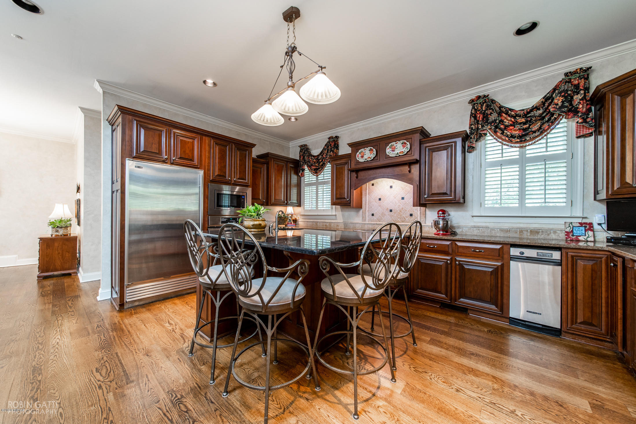 6356 New Forsyth Road Macon, GA 31210 - Photo 20 of 52 a kitchen with stainless steel appliances granite countertop a stove top oven a sink a dining table and chairs with wooden floor