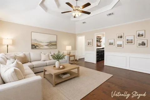 a living room with furniture and a view of kitchen