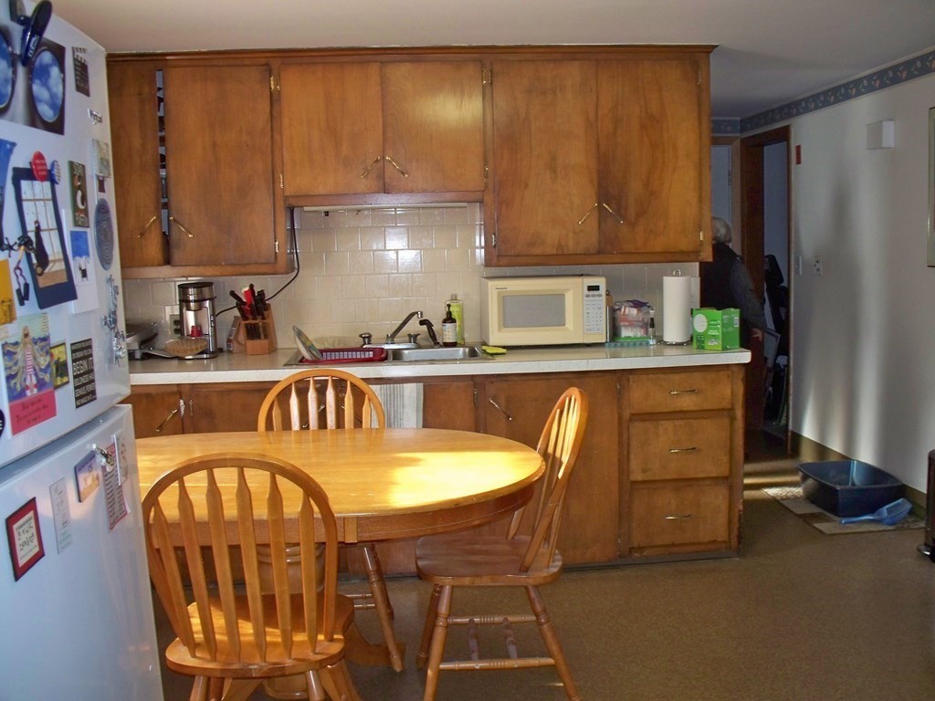 142 Killdeer Road Webster, MA 01570 - Photo 6 of 24 a kitchen with stainless steel appliances granite countertop a table chairs in it and a window