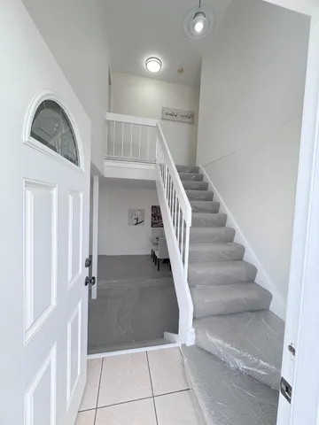 a view of staircase with white walls and railing