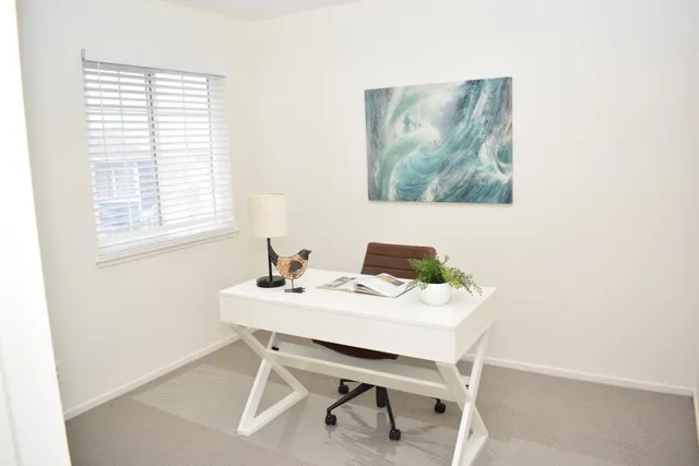 a view of a workspace with furniture and window