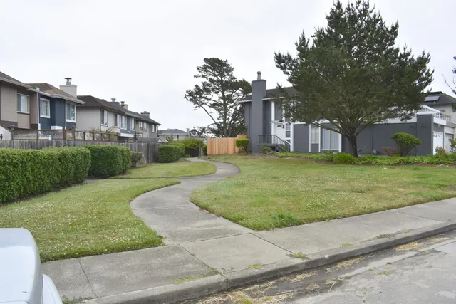 a view of a house with a yard and pathway