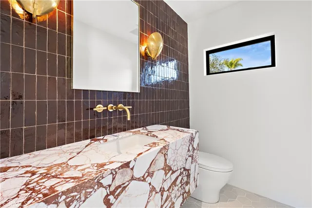 a bathroom with a sink a toilet and mirror