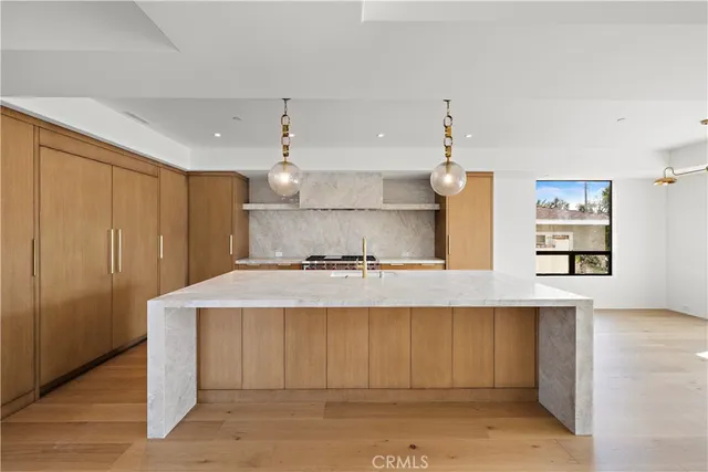 a kitchen with kitchen island a sink counter top space and cabinets