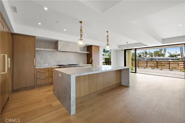 a large kitchen with stainless steel appliances kitchen island granite countertop a large counter top and wooden floors