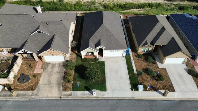 an aerial view of multiple houses with a yard