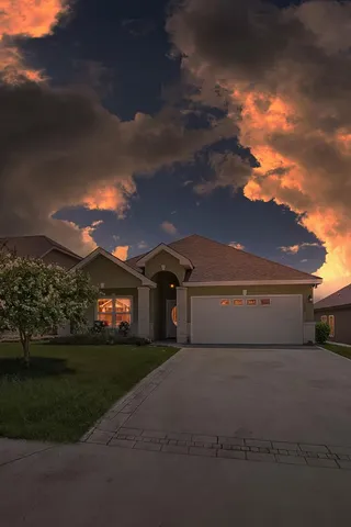 a front view of a house with a garden