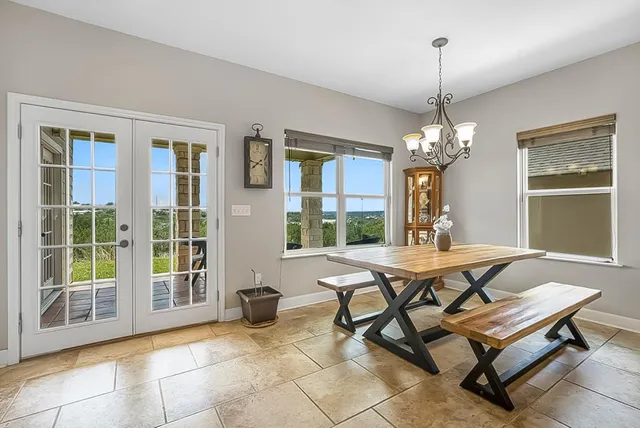a dining room with furniture a chandelier and window