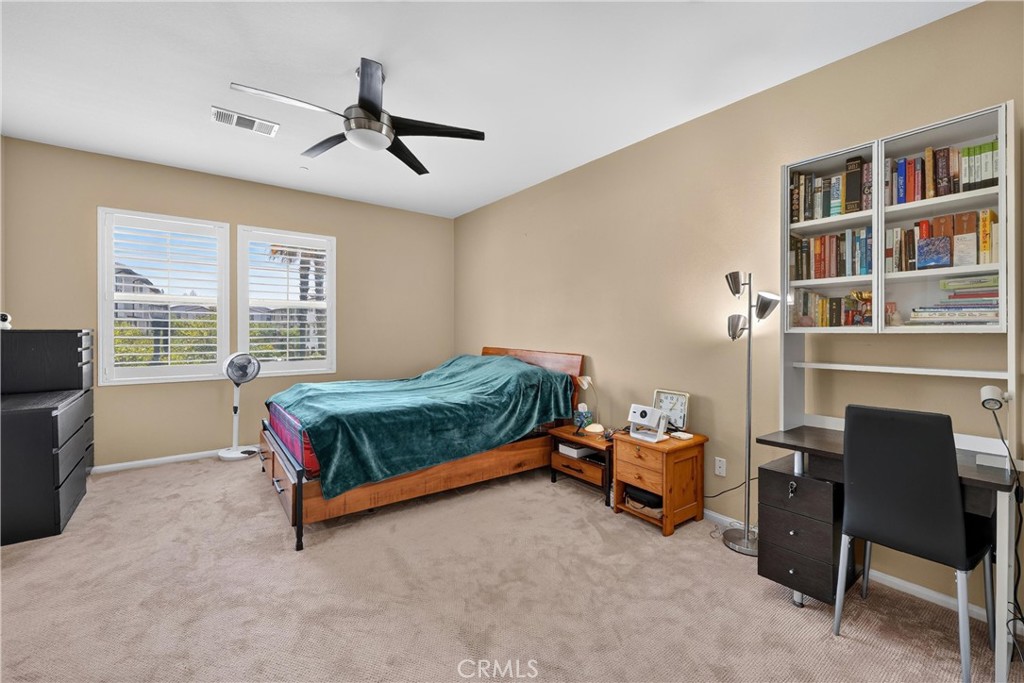 849 The Promenade, Unit D Azusa, CA 91702 - Photo 23 of 37 a bedroom with a bed and a book shelf