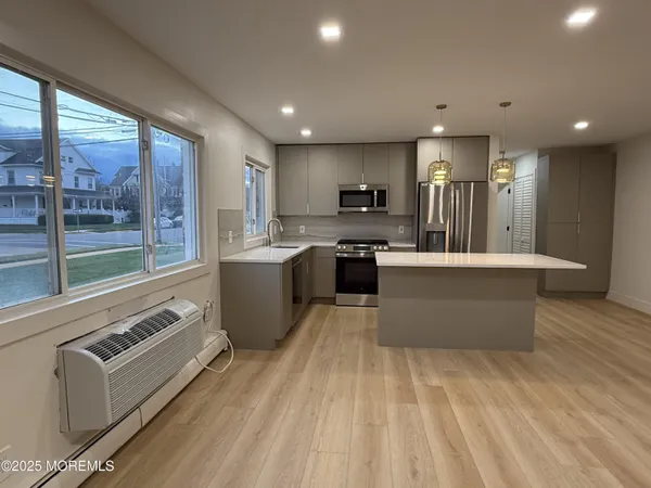 a large kitchen with stainless steel appliances granite countertop a stove and a sink