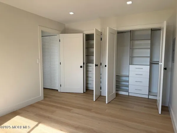 an empty room with closet and wooden floor