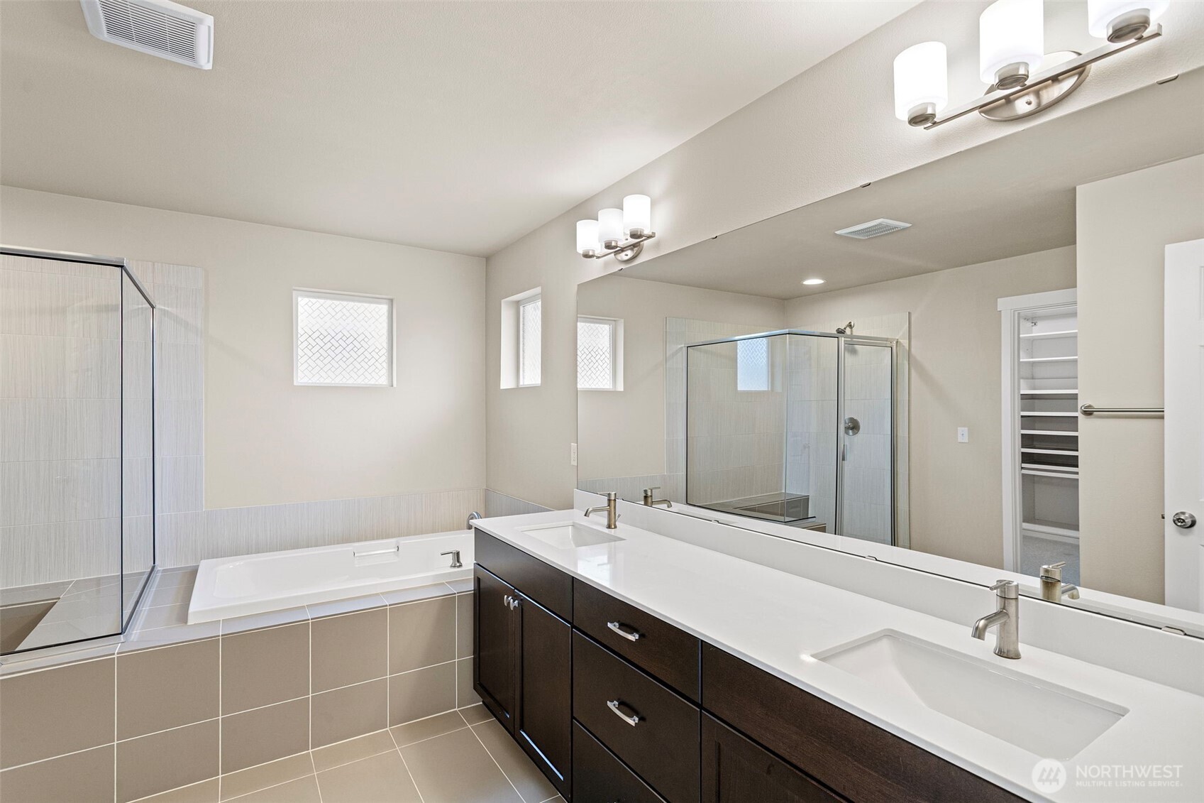 17913 38th Drive Southeast, Unit 20 Bothell, WA 98012 - Photo 23 of 32 a bathroom with a double vanity sink large mirror and a bathtub