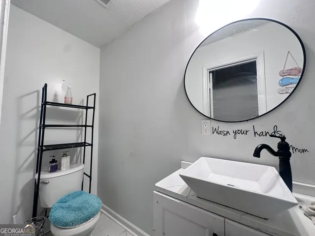 a bathroom with a sink toilet and a mirror