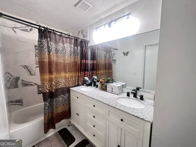 a bathroom with a granite countertop sink toilet and shower