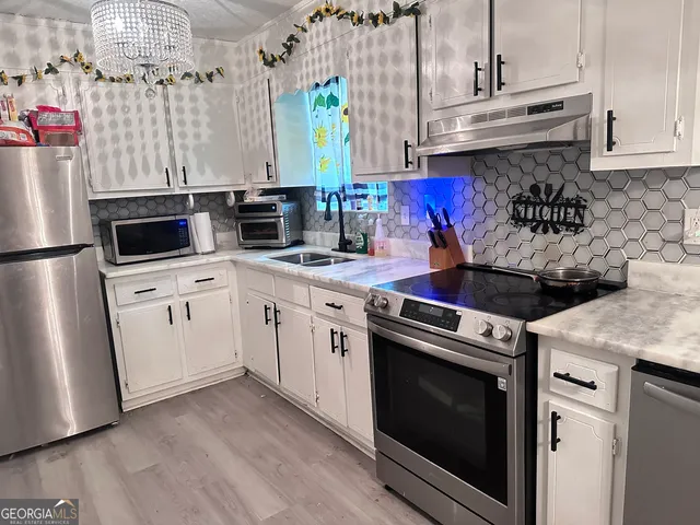 a kitchen with stainless steel appliances granite countertop a stove a sink and a refrigerator