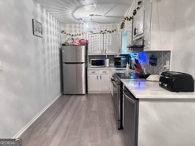 a kitchen with a refrigerator a stove top oven a sink and dishwasher