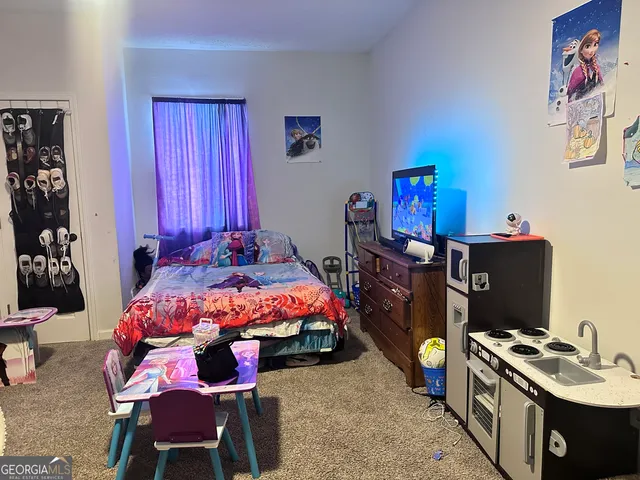 a bedroom with a bed and a dresser in it