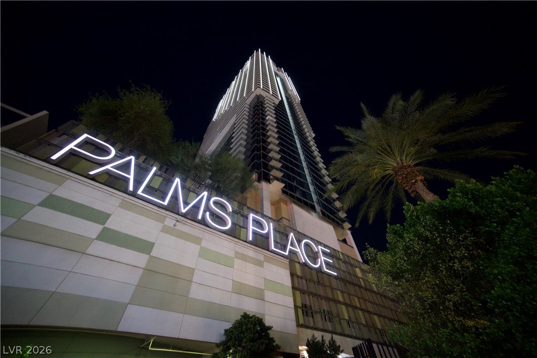 The striking, illuminated facade of Palms Place rises against the night sky.